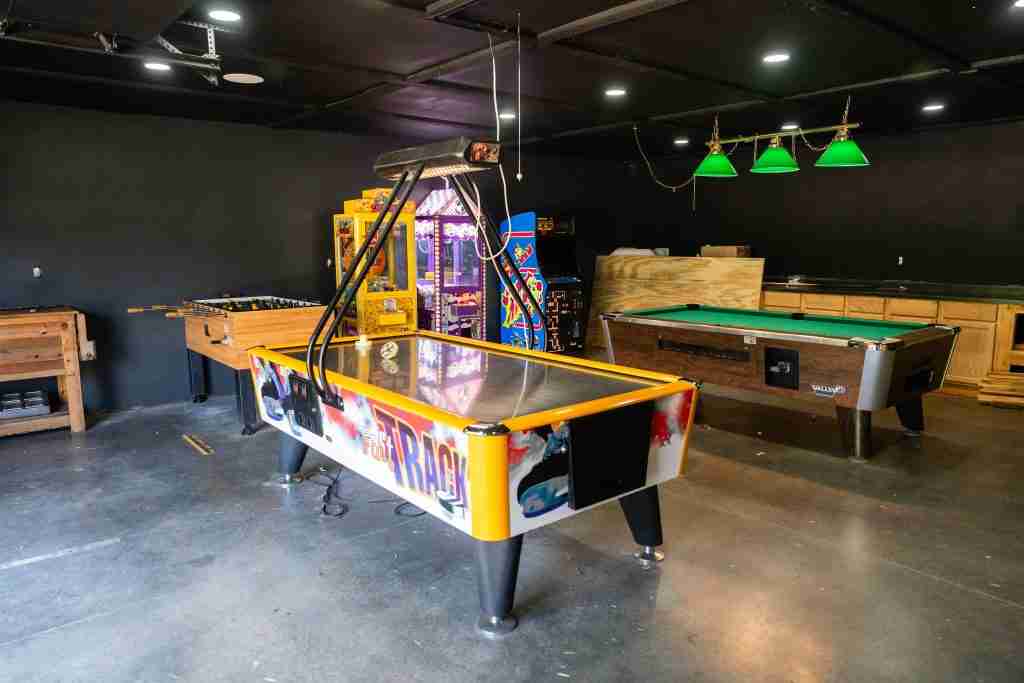 Game room with air hockey, pool table, and arcade games at Heaven’s Up North Campground