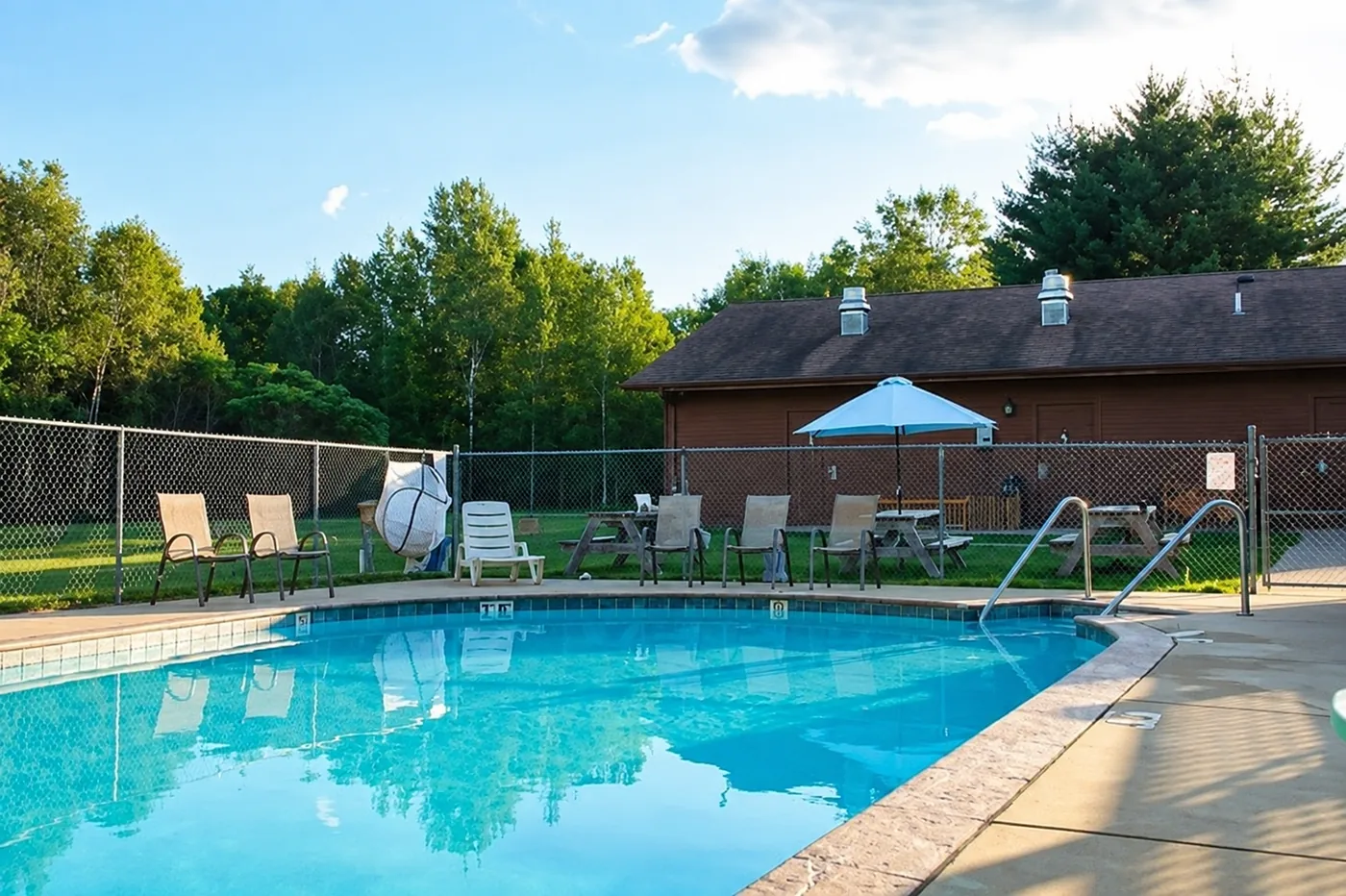 Outdoor heated pool with lounge chairs at the campground